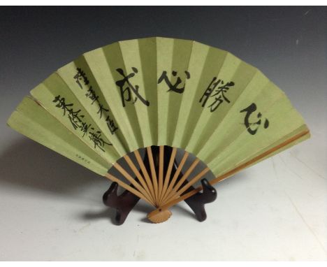 A Japanese WWII period eleven stick fan, issued by the Army Department under Hideki Tojo, the green canvas folds printed with