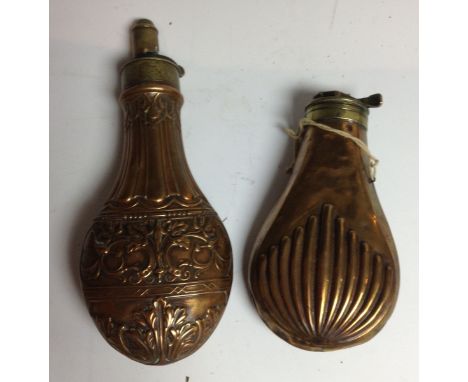 A 19th century brass and copper shot flask, embossed with strapwork and scrolling leaves, 21cm long; another (2)