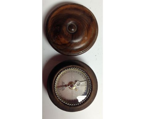 A treen travelling pocket compass, silvered register with rope-twist bezel, draught turned cover, 6.5cm diam