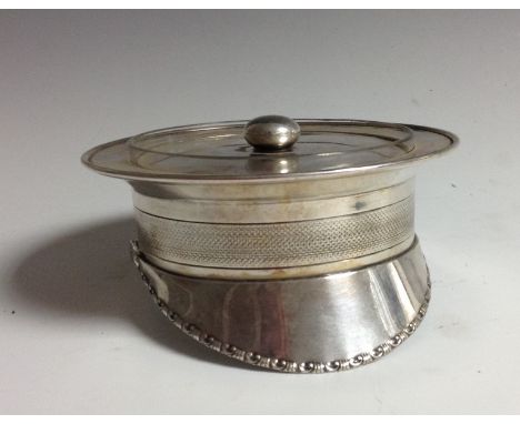 An Edwardian E.P.N.S novelty caviar dish, as a military officer's cap, bun finial, clear glass liner with star-cut base, engi