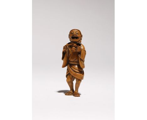 A JAPANESE WOOD NETSUKE OF A STREET ENTERTAINER MEIJI PERIOD, 19TH CENTURY Standing with his mouth wide open as he sings, bea
