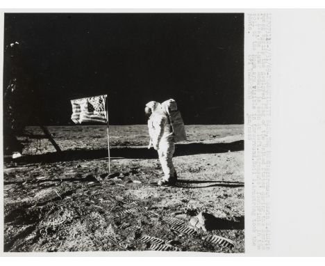 ** Apollo 11.-  Buzz Aldrin poses beside the U.S. flag, July 20, 1969, vintage gelatin silver print, U.P.I. caption recto, cr