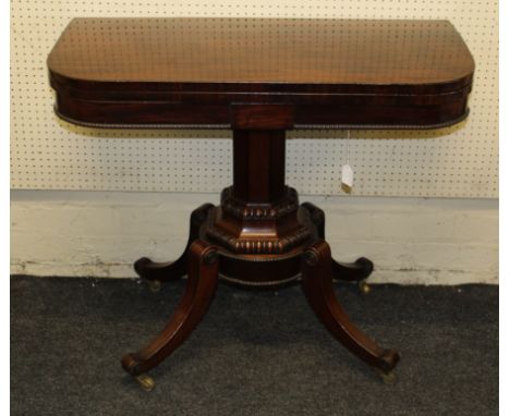 A Regency period mahogany foldover card table, the frieze centered with a rectangular panel over a beaded lower edge, on a fa