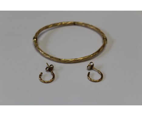 A twisted yellow metal hinged bangle marked 750 with Italian goldsmiths marks, 4.66 grams approximately, along with a pair of