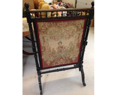 A large Victorian tapestry fire screen with turned wood supports and stretcher and galleried top.