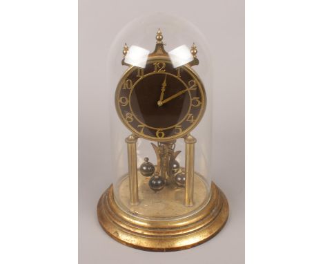 A Kieninger and Obergfell brass torsion clock with enamel dial.  