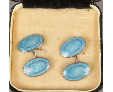 A pair of silver cufflinks with blue enamel decoration.  