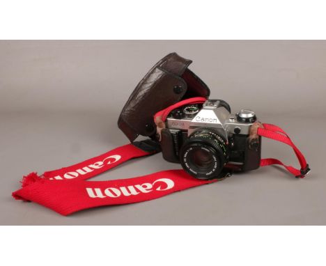 A Canon AE-1 SLR camera in leather case.  