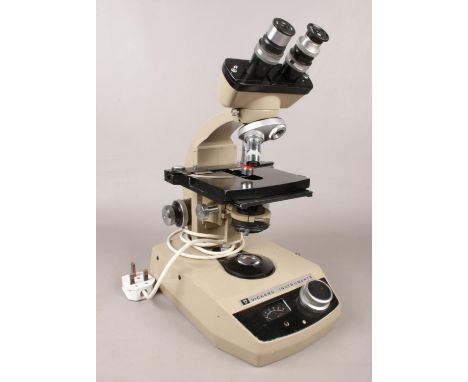 A Vickers instruments electric binocular microscope. B.D.U.S 66 - H: 39cm, W: 18cm.  Vendor confirms this item is working. No