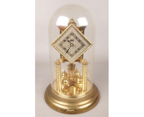 A Schatz brass torsion clock with diamond shape dial. Under dome.  