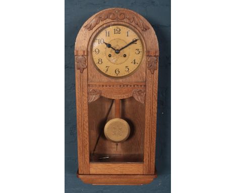 A carved light oak 8 day wall clock.  