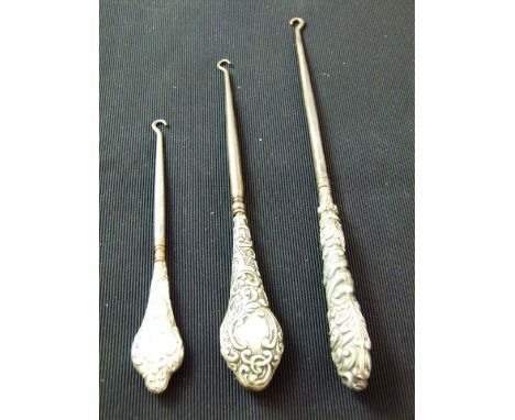 Three hallmarked silver handled button hooks, various assay and makers