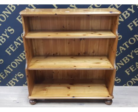 A PINE DUCAL THREE SHELF BOOKCASE WITH ADJUSTABLE TOP SHELF RAISED ON CASTORS TOGETHER WITH ANOTHER PINE BOOK SHELF