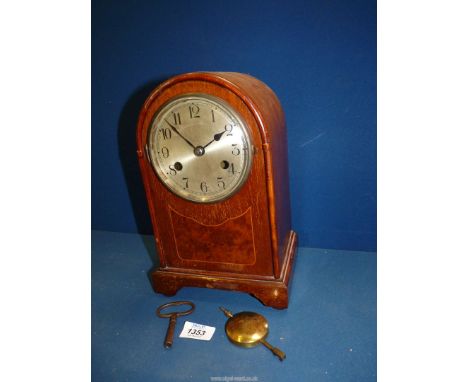 A dome shape Mantle clock, with key and pendulum, 7" wide x 11 1/4" tall.
