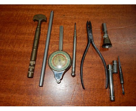 A pocket map distance measuring device, a small pair of possibly watchmaker's pliers, a brass glass cutter, a knurled metal b
