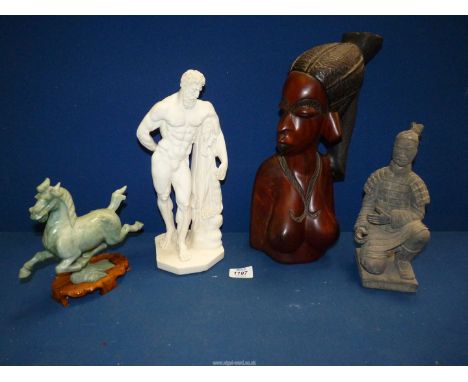 Four miscellaneous figures including; ethnic carved wooden bust of a woman, resin figure of a Herucles in classic pose, green