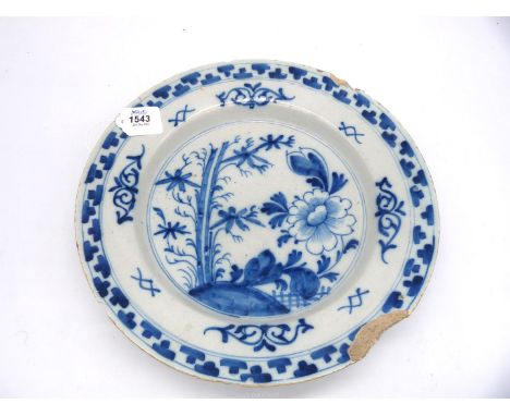A large Delftware charger painted with flowers in blue, English, mid-18th century, a/f., 13 1/2" diameter x 2 1/4" deep.