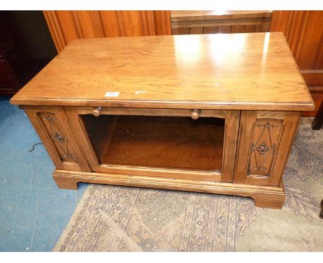 A mid Oak TV stand with a glazed doored compartment and recessed store shelf, 33'' x 7 5/8'' x 17'' high.