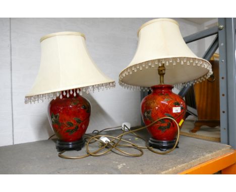 Pair of red bulbous ceramic lamp bases with beaded cream shades