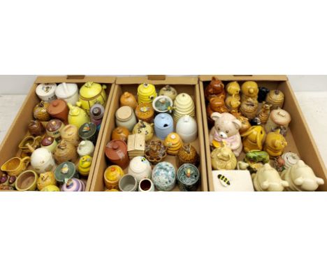 A large collection of various ceramic honey pots, to include examples in the form of bee skeps, etc. - Condition Report 