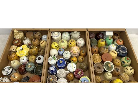 A large collection of various ceramic honey pots, to include examples in the form of bee skeps, etc. - Condition Report 