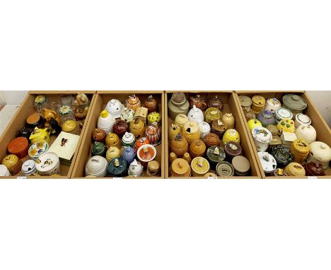 A large collection of various ceramic honey pots, to include examples in the form of bee skeps, etc. - Condition Report 