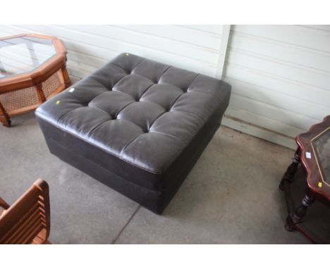 A large leatherette upholstered button down pouffe