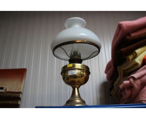 A brass oil lamp with milk glass shade