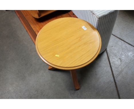 A light oak circular topped table raised on tripod base