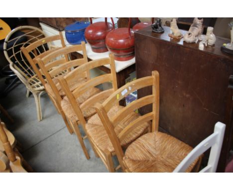 A set of four beech ladder back dining chairs