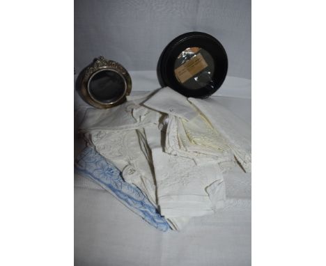 A modern white metal photograph frame stamped 925 of circular form having applique decorative crest top and plastice stand, a