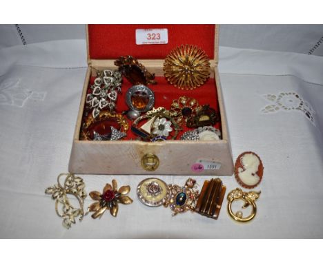 A small vintage jewellery box containing a selection of costume jewellery brooches