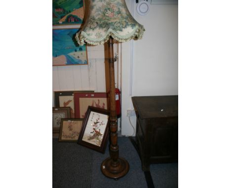An oak standard lamp with tassled shade