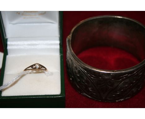 A 9ct gold single stone diamond ring and a silver hinged bangle