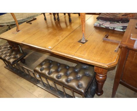 A late Victorian light oak extending dining table with two leaves