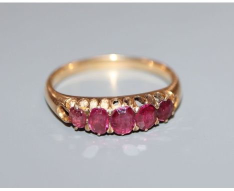 A yellow metal and graduated five stone ruby half hoop ring, size O.