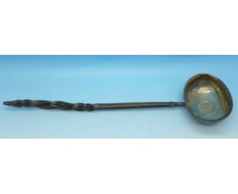 A ladle with an inlaid George III silver coin and a whalebone handle