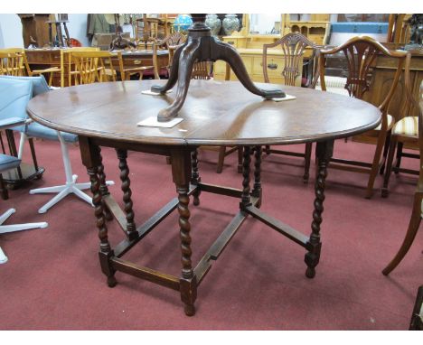 A 1920's Oak Gate Leg Table, with fall leaves to oval top, on barley twist supports.