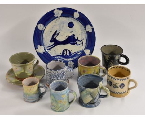 Studio Pottery - a tin glazed earthenware plate,  by Carol Kimbell, signed, 28cm diameter;  eight studio pottery mugs by vari