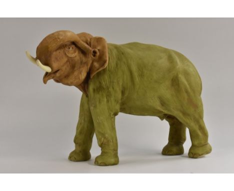 A large  Royal Dux model of an elephant, trunk raised, in green and brown, 35cm high, unmarked