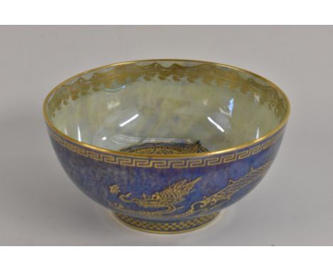 A Wedgwood Dragon Lustre bowl, designed by Daisy Makeig Jones, the exterior printed in gilt with a dragon on a mottled blue g