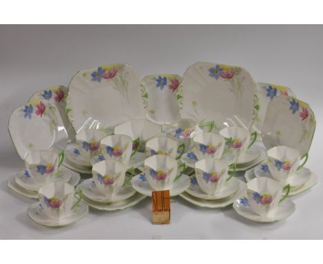 A Shelley Queen Anne shape Anemone pattern  tea service, for twelve, decorated with red, yellow and blue flowers, green line 