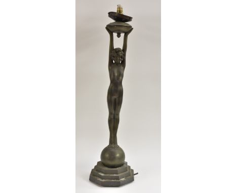 An Art Deco spelter table lamp, of a young naked girl, standing on a sphere, stretching her arms to hold the lamp, stepped oc