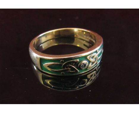 A 9ct gold ring with a green enamel Celtic design to front set with a single diamond. Size P/Q, 3.9g