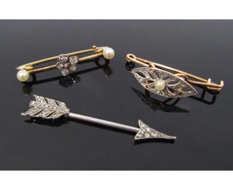 A diamond set "arrow" tie pin, 3.8cm long, 1.8g unmarked with two diamond and pearl bar brooches, one as a pansy, unmarked, 2