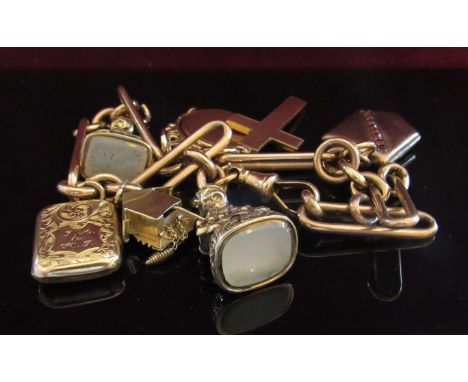 A 9ct gold charm bracelet made from a watch chain, hung with various charms including seal fobs, cuckoo clock, cross and phot