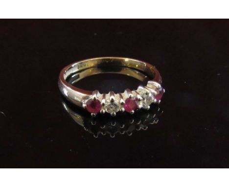 A 9ct gold five stone diamond and ruby ring. Size P, 2g