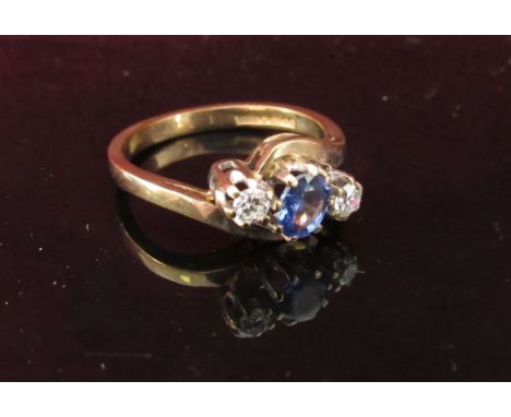 A 9ct gold sapphire and diamond cross-over ring. Size J/K, 2.2g