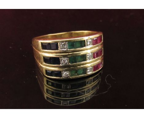 A gold ring with three rows of sapphires, diamonds and emeralds, stamped 18k. Size Q/R, 7.8g