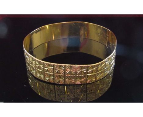 A gold bangle with starcut design, 16mm wide, misshapen, 31g